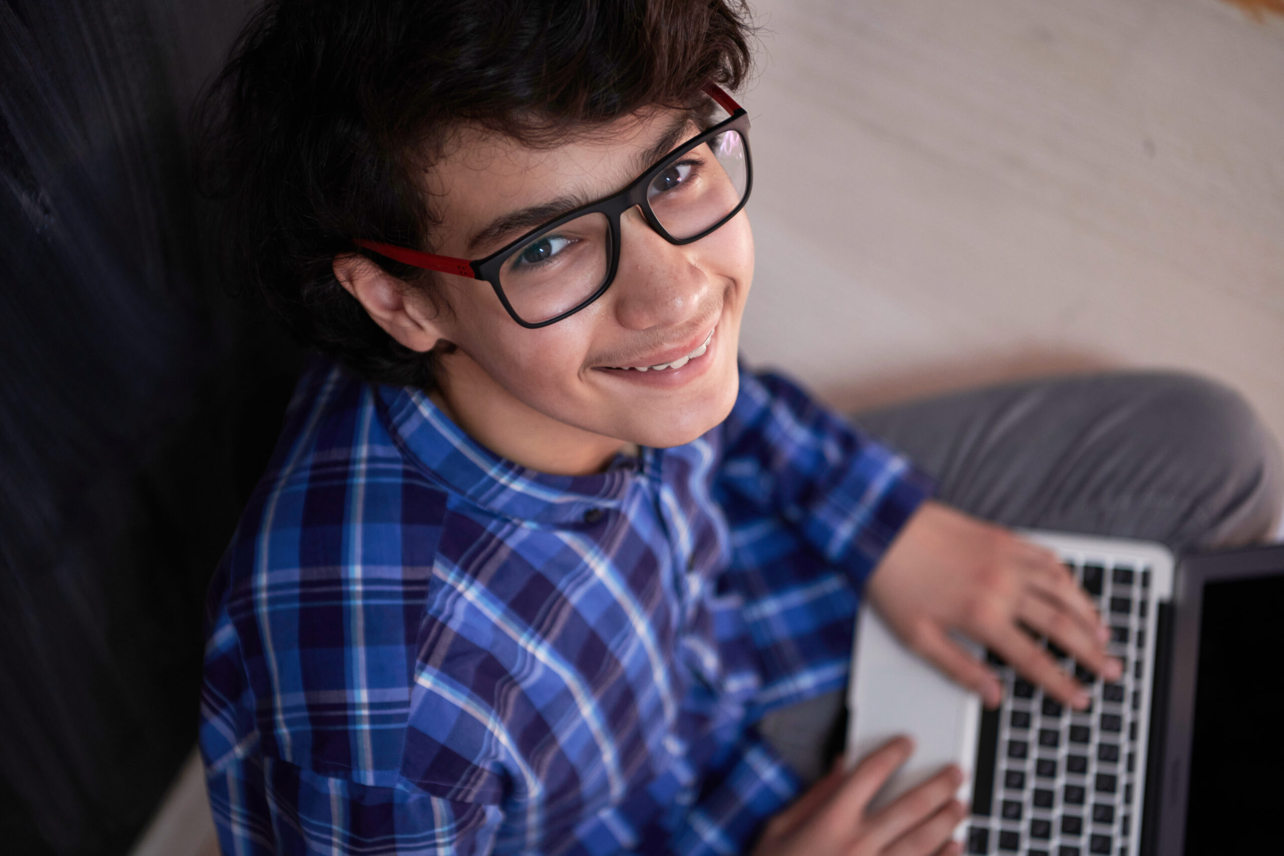 Arab,Teenager,Using,Laptop,To,Work,On,Homework,And,Watch