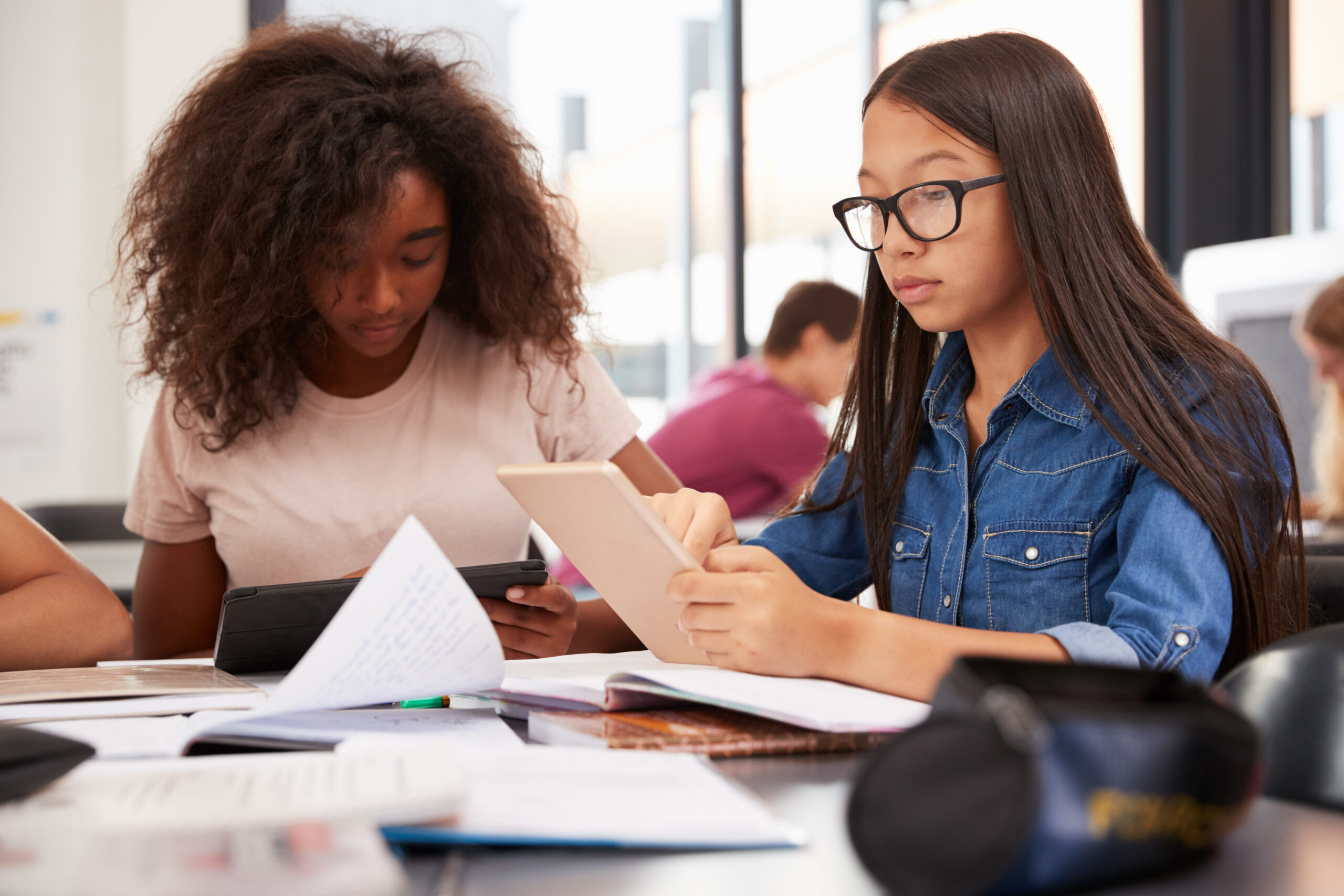 Two,Teenage,Schoolgirls,Using,Tablet,Computers,In,Class